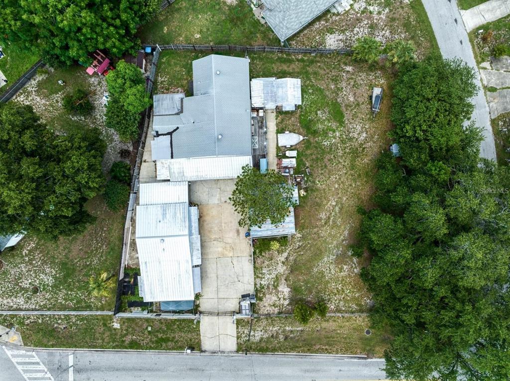 An aerial view shows a house with a metal roof, concrete driveway, and large yard — 1769 OVERBROOK AVENUE, CLEARWATER, FL