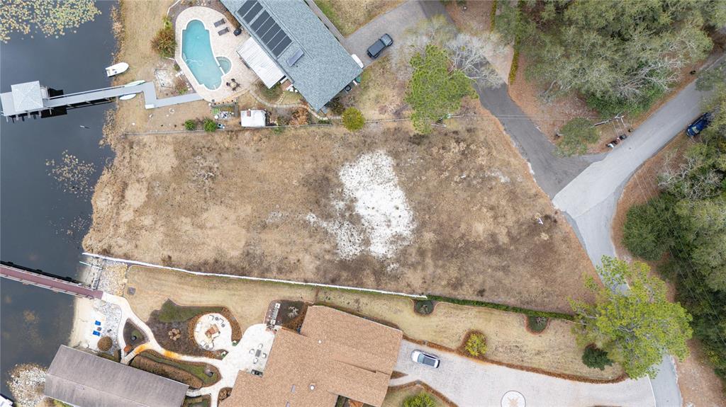An aerial view shows a vacant waterfront lot situated between two residential properties — 601 TUSCANY COURT, SANFORD, FL