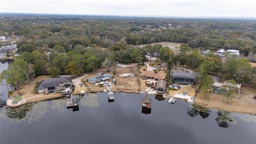 An aerial view shows several waterfront houses with private docks along a lake — 601 TUSCANY COURT, SANFORD, FL