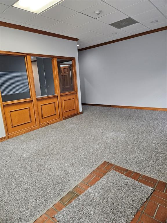 An office interior features gray carpet, wood-framed glass partitions, and a brick-tiled entryway — 2389 RINGLING BOULEVARD UNIT A, SARASOTA, FL