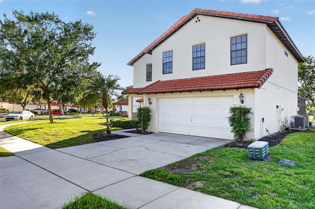 A two-story house with a white stucco exterior, a tile roof, and a two-car garage — 126 SUMMER PLACE LOOP, CLERMONT, FL