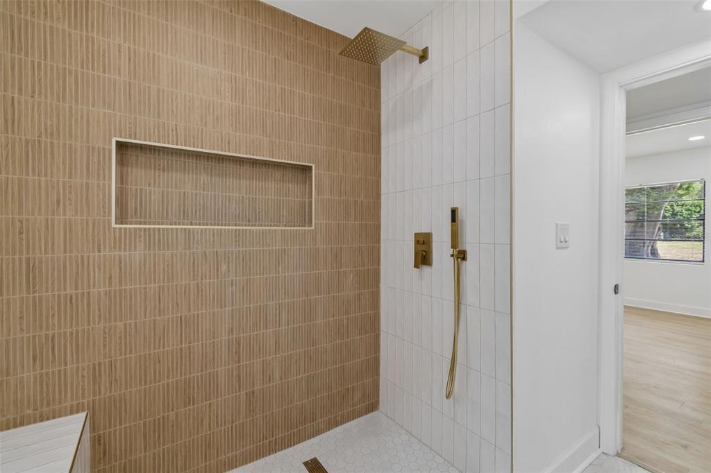 A bathroom shower features olive green vertical tiles, white wall tiles, and gold-toned fixtures — 1702 W JOHNSTON AVENUE, TAMPA, FL