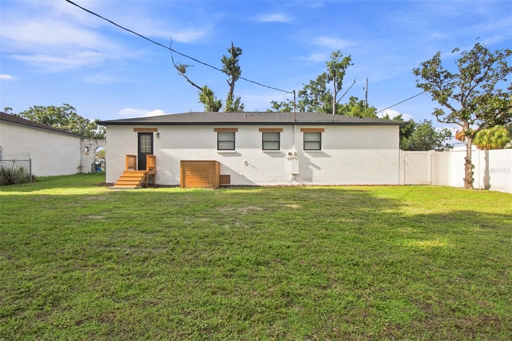 An aerial view shows a single-story house outlined in red near a school campus — 1702 W JOHNSTON AVENUE, TAMPA, FL