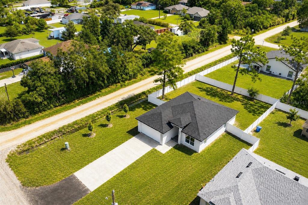 This aerial map shows a vacant, wooded rectangular lot outlined in blue near a road — 995 9TH AVENUE, DELAND, FL
