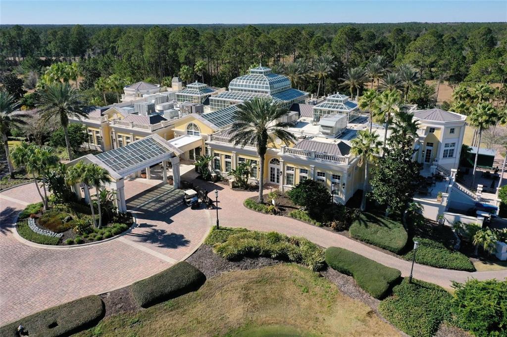 An aerial view of a large yellow building with glass conservatory roofs and palm trees — 631 MAHOGANY RUN, PALM COAST, FL