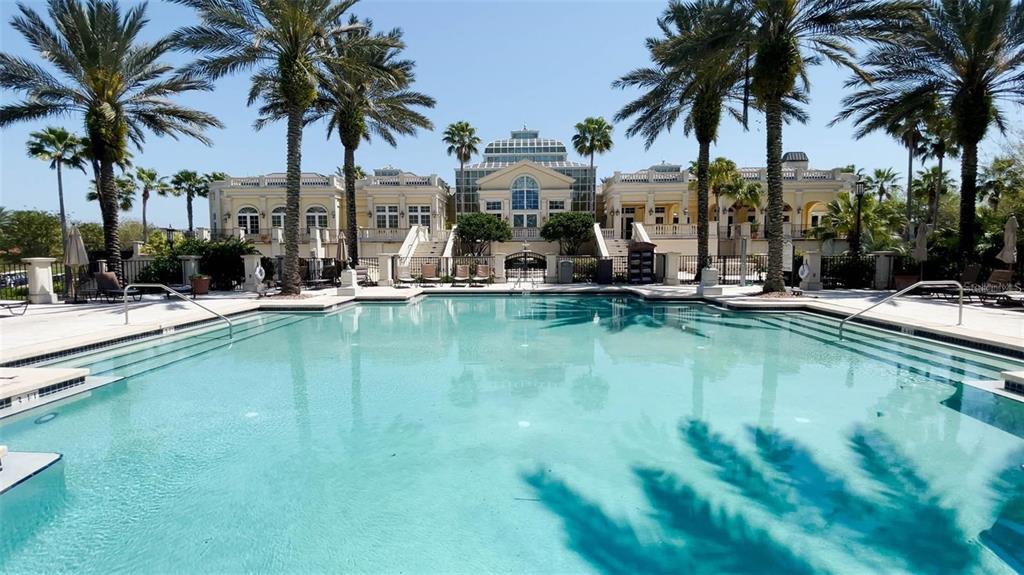 A large swimming pool sits in front of a grand building with palm trees — 631 MAHOGANY RUN, PALM COAST, FL