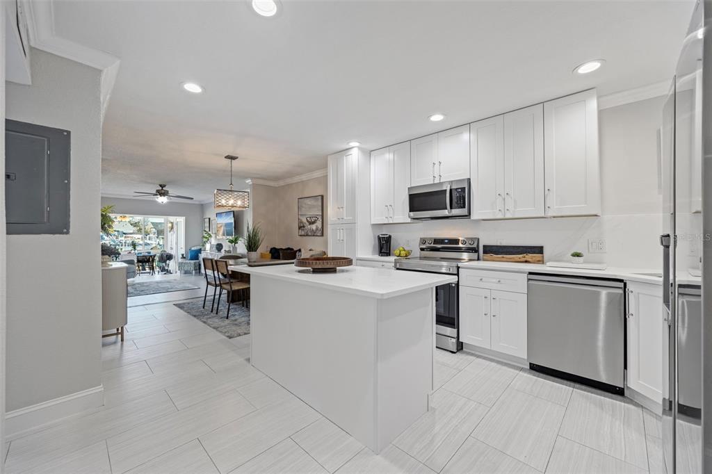 A modern kitchen with white cabinets, a central island, and stainless steel appliances — 1008 APOLLO BEACH BOULEVARD UNIT 103, APOLLO BEACH, FL