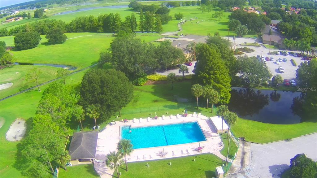 An aerial view of a swimming pool located next to a golf course and parking lot — 508 EAGLE POND DRIVE UNIT 508, WINTER HAVEN, FL