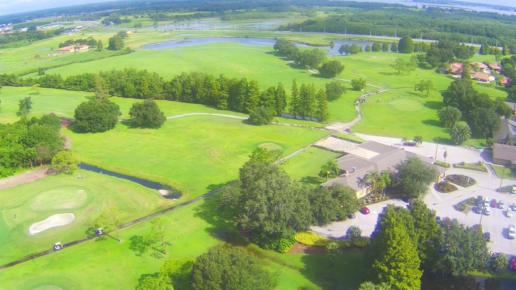 An aerial view of a golf course clubhouse with a parking lot and surrounding green fairways — 508 EAGLE POND DRIVE UNIT 508, WINTER HAVEN, FL