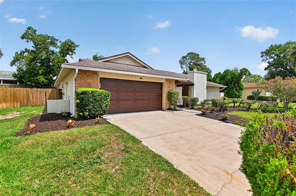 A single-story house features a brown garage door, stone accents, and a concrete driveway — 3179 FOXWOOD DR, APOPKA, FL