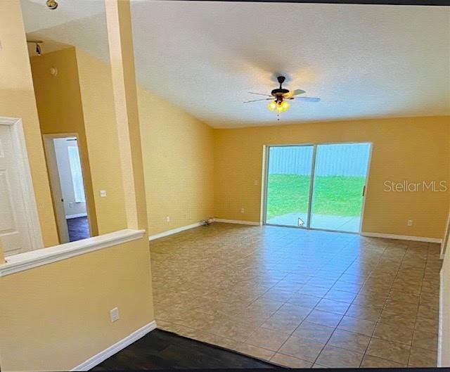 A spacious living area features tile flooring, a ceiling fan, and sliding glass doors — 40107 OAKRIDGE DRIVE, LADY LAKE, FL