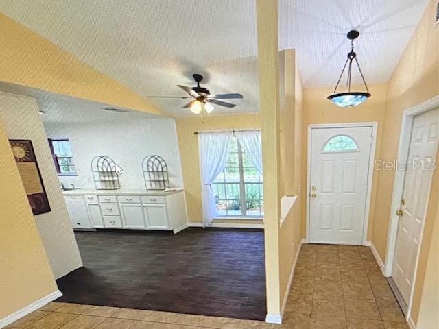 An interior view shows a kitchen with white cabinets, a dining area, and an entryway — 40107 OAKRIDGE DRIVE, LADY LAKE, FL