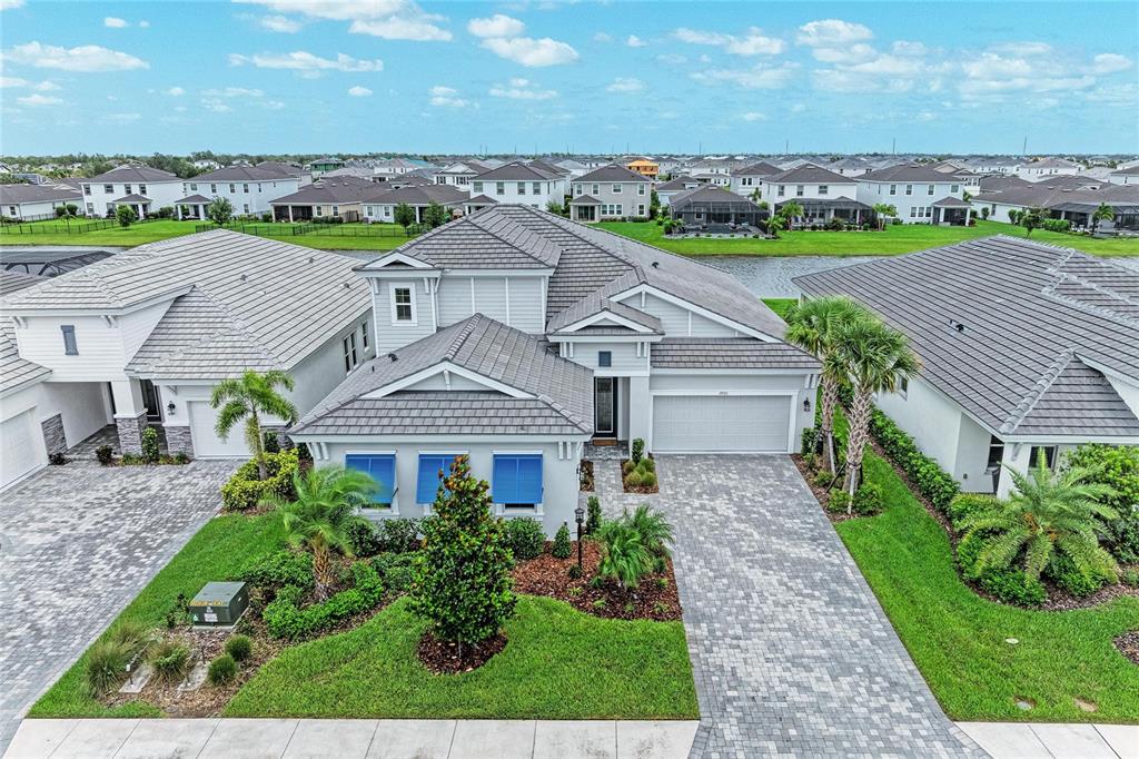 A single-story house with a paved driveway, a two-car garage, and a landscaped front yard — 17725 ROOST PLACE, LAKEWOOD RANCH, FL