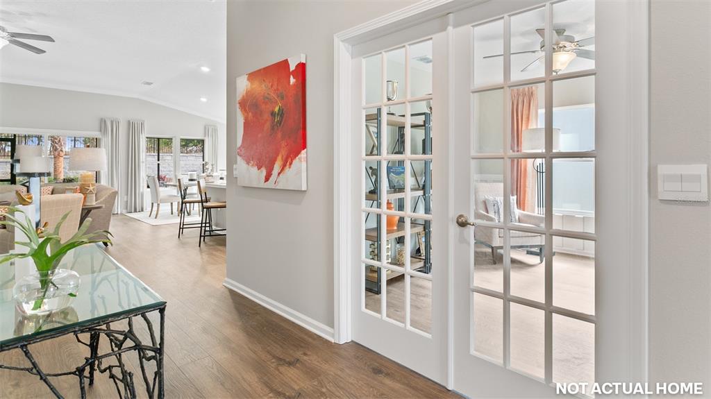 This rendering shows a hallway with a glass-topped table, abstract wall art, and French doors — 52 HARDWOOD TRAIL, PALM COAST, FL