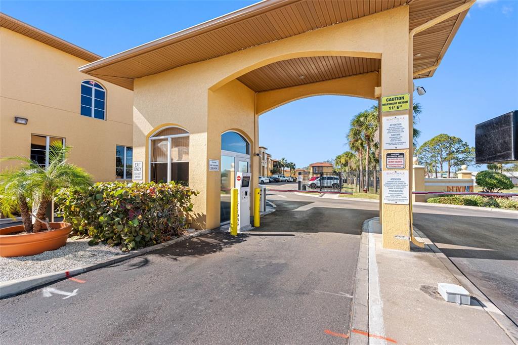 An exterior view of a gated entrance with a yellow stucco archway and signage — 4323 BAYSIDE VILLAGE DRIVE UNIT 329, TAMPA, FL
