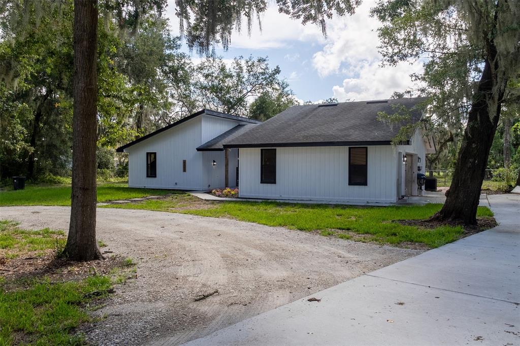 A room with light wood flooring features a console table and a desk near a doorway — 4212 HOMEWOOD LANE, LAKELAND, FL