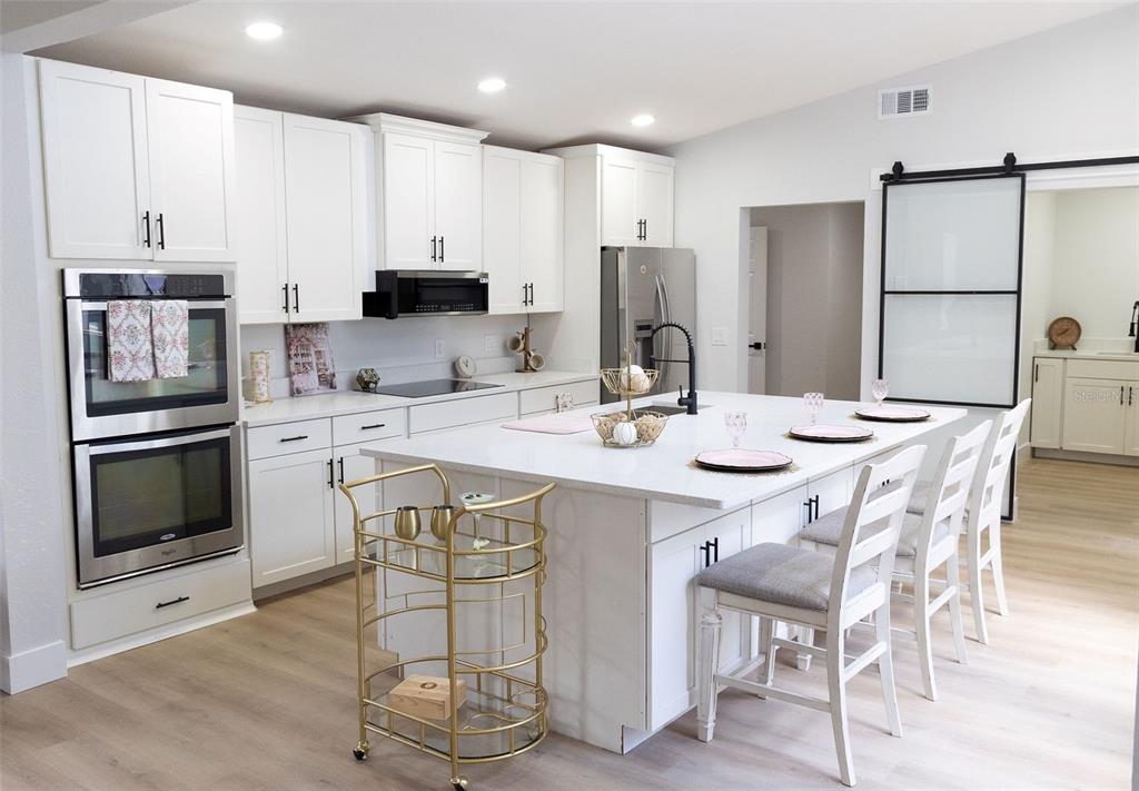 A home office features light wood flooring, a white desk, and a shiplap accent wall — 4212 HOMEWOOD LANE, LAKELAND, FL