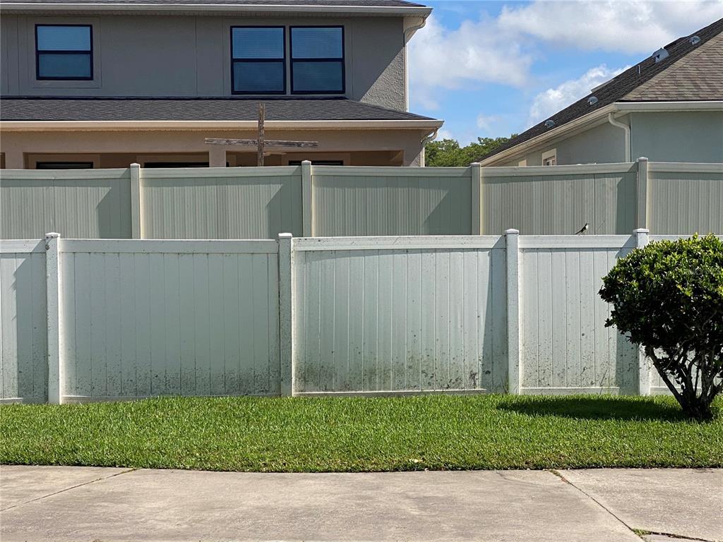 A paved parking lot sits in front of a residential building surrounded by trees — 2706 RIO GRANDE TRAIL UNIT 2706, KISSIMMEE, FL