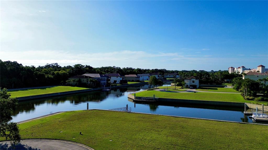 An aerial view shows a canal winding through a residential neighborhood with green lawns — 5 SCHOONER CIRCLE, PALM COAST, FL
