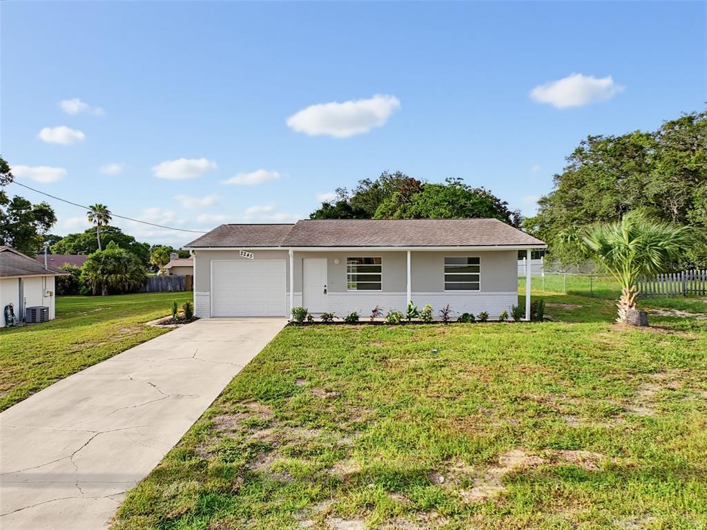 A single-story house with a white garage, gray exterior, and a concrete driveway — 2245 BISHOP ROAD, SPRING HILL, FL