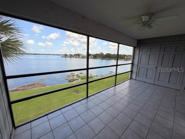 A screened-in porch with tiled flooring overlooks a lake and a grassy lawn — 4109 FAIRVIEW VISTA POINT UNIT 315, ORLANDO, FL