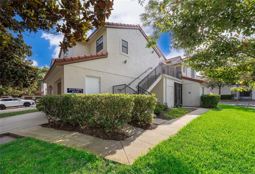 A two-story residential building features a stucco exterior, a tiled roof, and an outdoor staircase — 520 VIA VERONA LANE UNIT 203, ALTAMONTE SPRINGS, FL