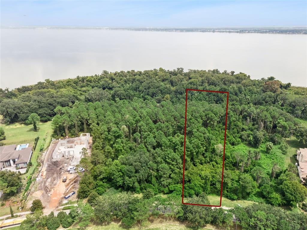 An aerial view shows a rectangular plot of land outlined in red near a lake — 17131 ETRUSCAN LANE, MONTVERDE, FL