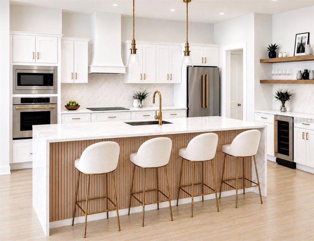 A modern kitchen features a white marble island with bar stools and gold hardware accents — 18924 NORTHROP STREET, ORLANDO, FL