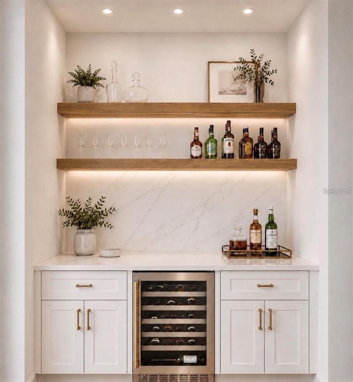 A home bar features white cabinets, a wine cooler, marble backsplash, and two wooden shelves — 18924 NORTHROP STREET, ORLANDO, FL