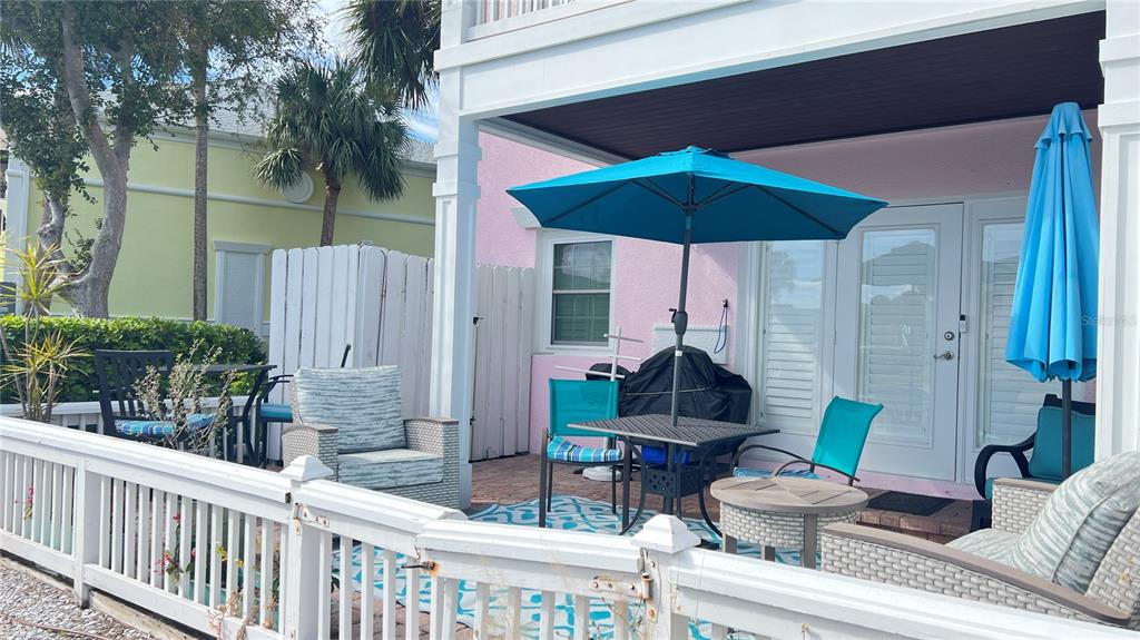 A living room with yellow walls, tile flooring, a sofa, a coffee table, and glass doors — 5164 BEACH DRIVE SE UNIT B furnished, ST PETERSBURG, FL