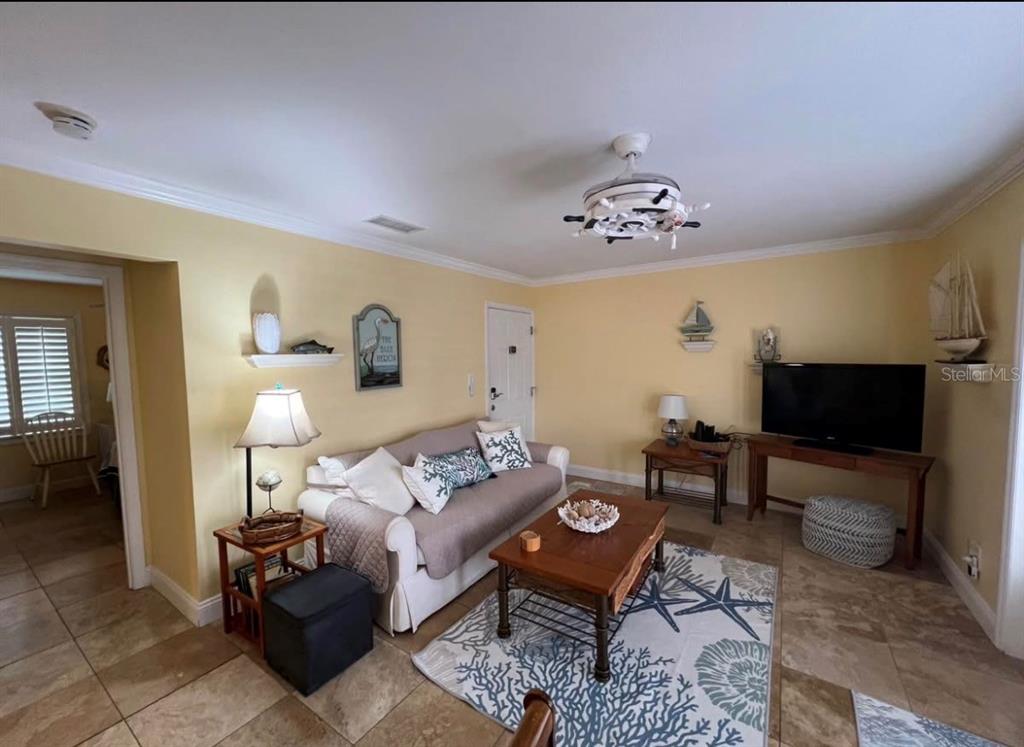 A kitchen features white cabinetry, a stainless steel refrigerator, and a built-in wall oven — 5164 BEACH DRIVE SE UNIT B furnished, ST PETERSBURG, FL