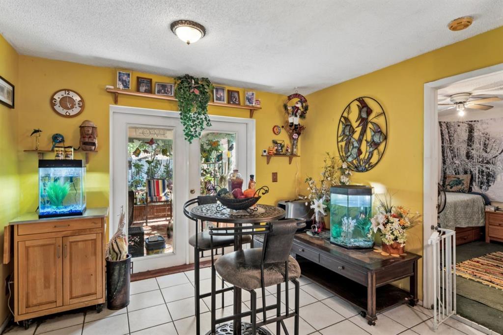 A dining area with yellow walls, tile floors, a bistro table, and two fish tanks — 2005 HUDSON CT, OLDSMAR, FL