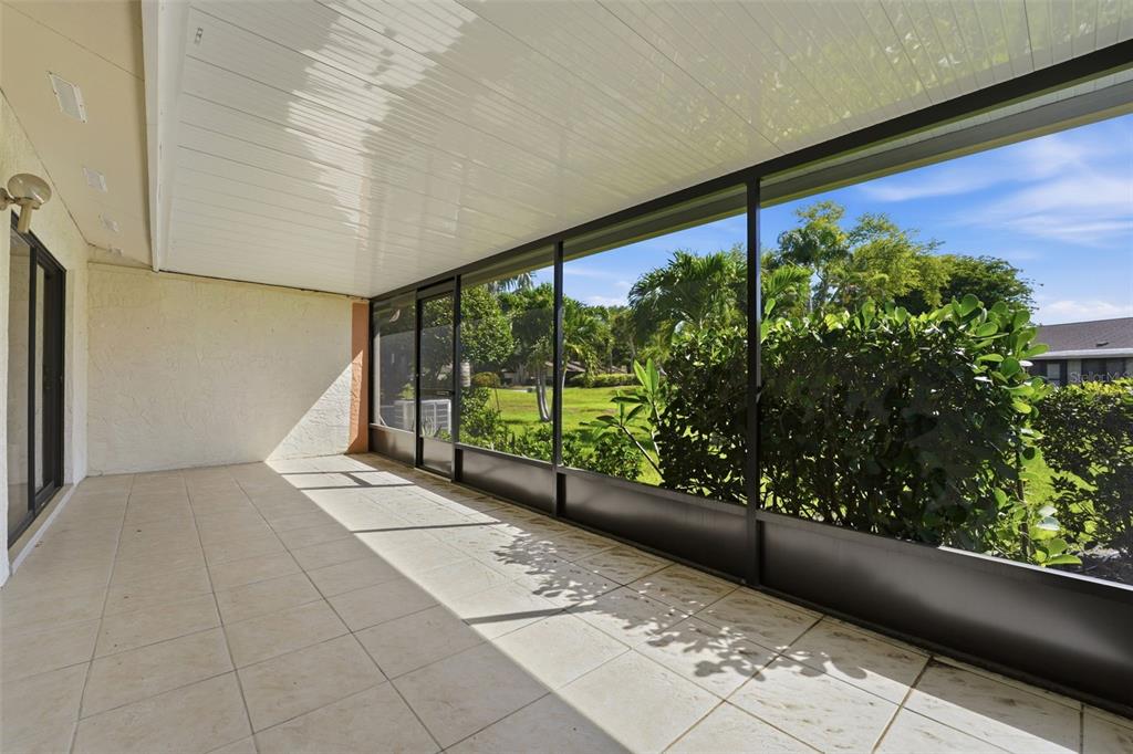 A room with tile flooring, white walls, a front door, and two patterned armchairs — 6132 29TH AVENUE W UNIT 6132, BRADENTON, FL