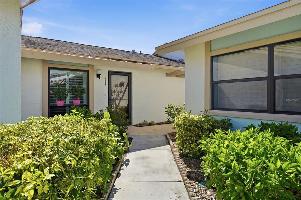 A living room with white walls, tile flooring, a ceiling fan, and patterned furniture — 6132 29TH AVENUE W UNIT 6132, BRADENTON, FL