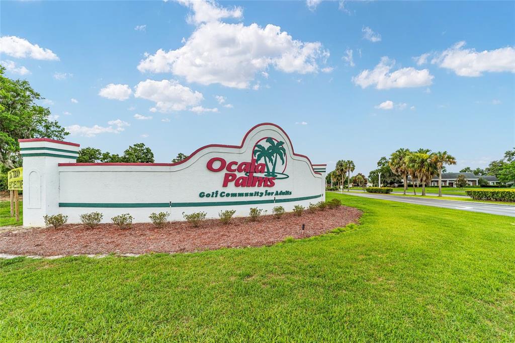 A white monument sign for Ocala Palms Golf Community for Adults stands on a grassy lawn — 1923 NW 50TH CIRCLE, OCALA, FL