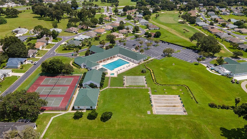 An aerial view shows a community clubhouse with a pool, tennis courts, and shuffleboard courts — 1923 NW 50TH CIRCLE, OCALA, FL