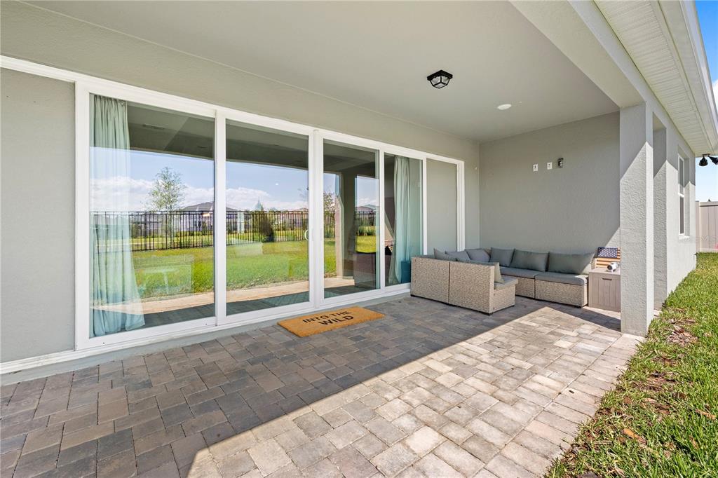 A kitchen features white cabinetry, a central island with bar stools, and light wood flooring — 5269 FOOTHILLS PRESERVE LOOP, MOUNT DORA, FL