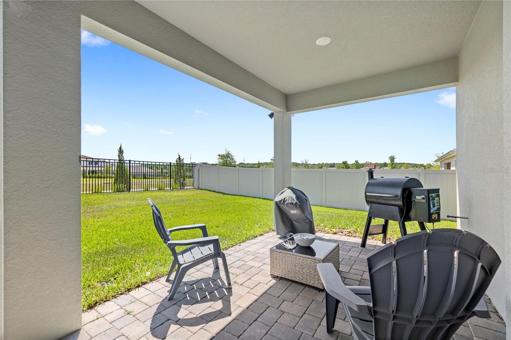 A modern kitchen features white cabinets, a gray island with bar seating, and wood flooring — 5269 FOOTHILLS PRESERVE LOOP, MOUNT DORA, FL