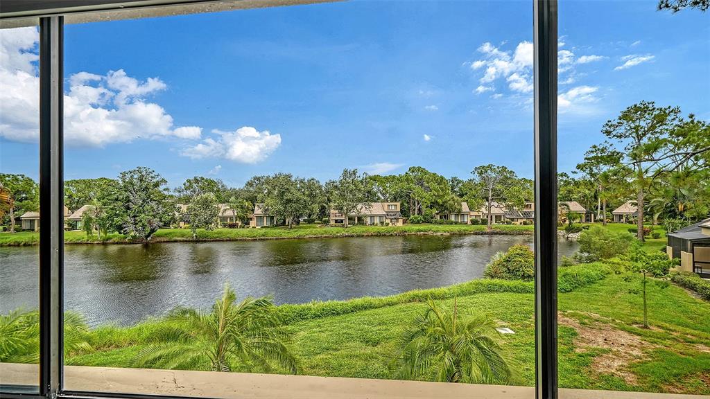 A view of a lake and residential houses seen through a screened-in porch window — 5315 MYRTLE UNIT 46, SARASOTA, FL