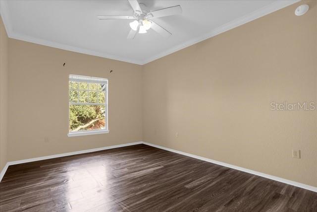 A living room with wood-look flooring, a ceiling fan, built-in shelving, and an adjacent kitchen — 246 VILLA DI ESTE TERRACE UNIT 200, LAKE MARY, FL