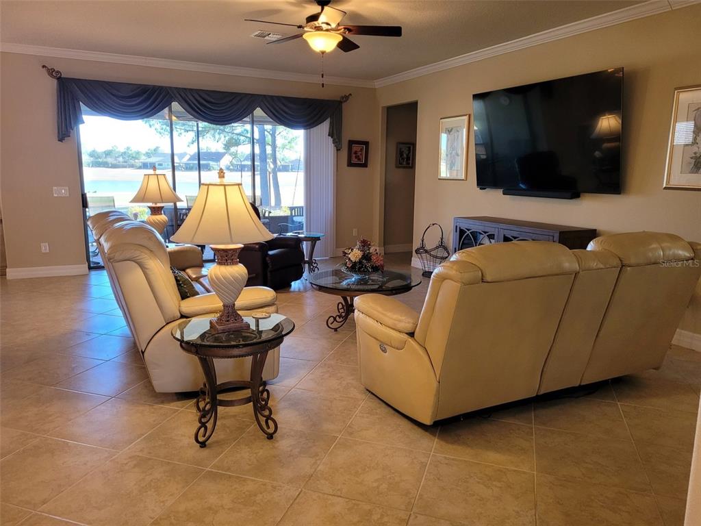 A view of a golf course and pond from a grassy backyard with pine trees — 6443 SW 97TH TERRACE ROAD, OCALA, FL