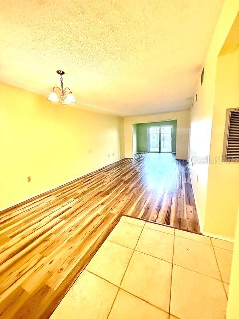An empty room features light-colored walls and wood-look flooring with a single window — 4111 HERON WAY UNIT E-103, BRADENTON, FL