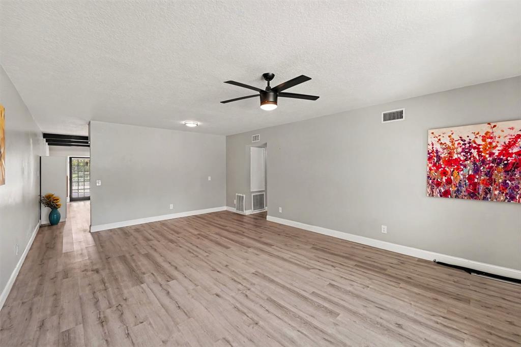 An empty living room with light wood-look flooring, gray walls, and a ceiling fan — 2262 SWEDISH DRIVE UNIT 14, CLEARWATER, FL