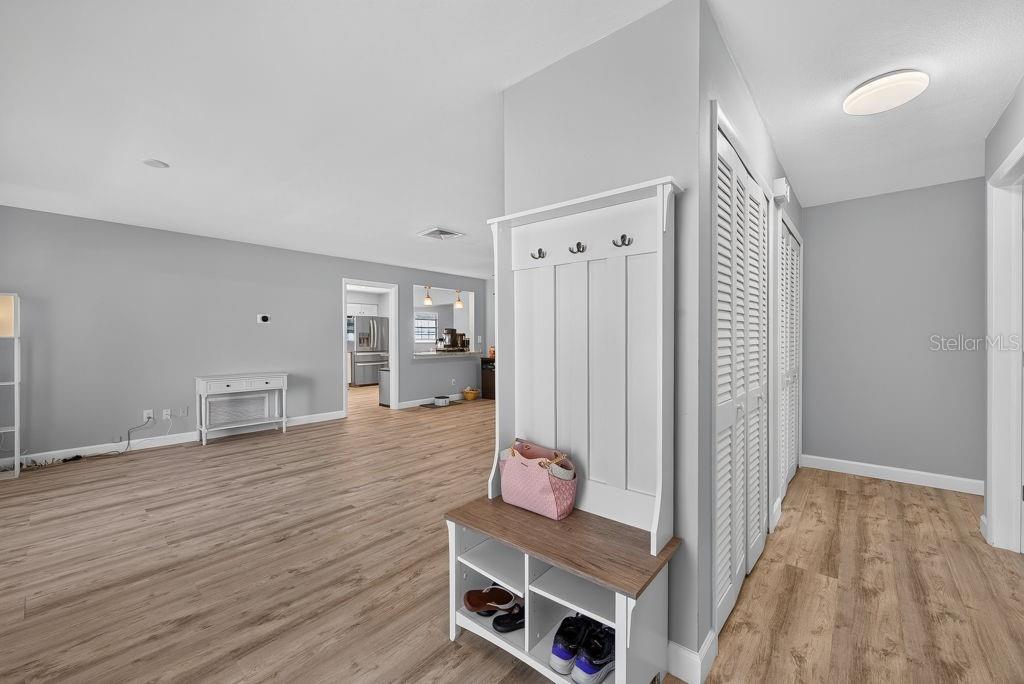 A white entryway hall tree stands in a room with light wood-look flooring — 2159 GREENBRIAR BOULEVARD, CLEARWATER, FL