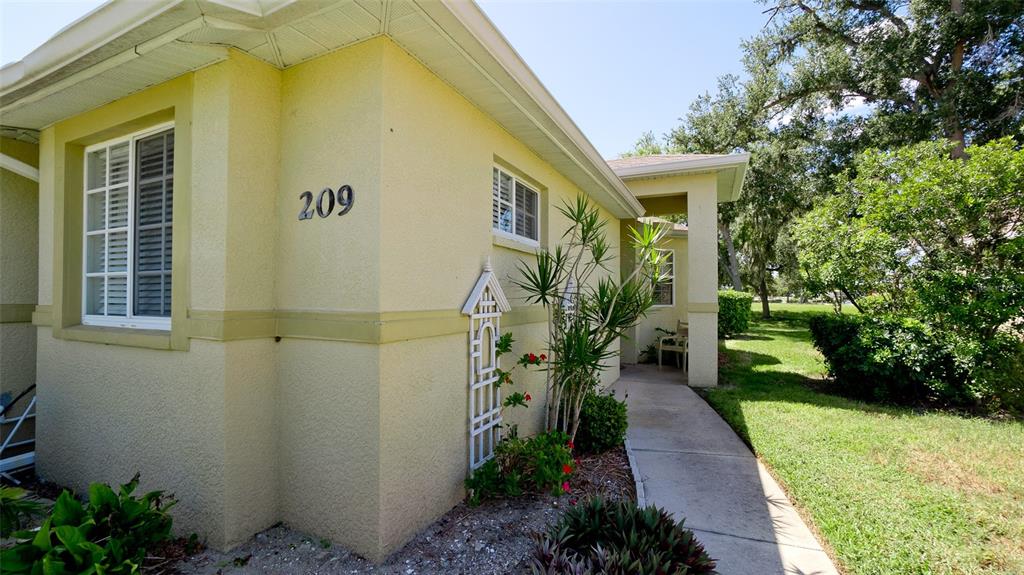 A yellow house exterior features a concrete walkway leading to the front entrance — 209 28TH STREET W, PALMETTO, FL