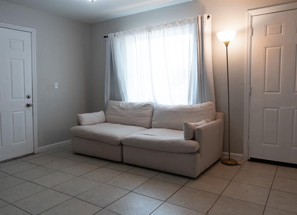 A living room features a white sofa, a floor lamp, and tile flooring — 3667 135TH AVENUE, LARGO, FL