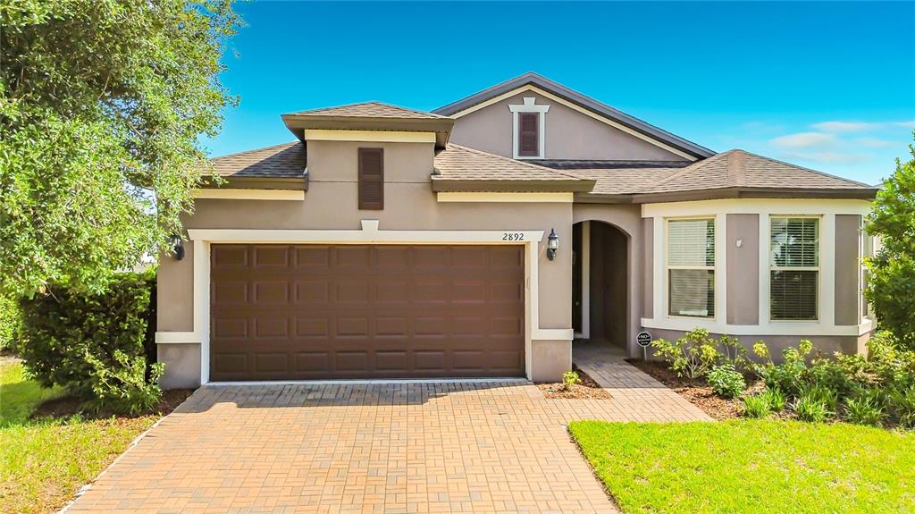 A side yard with a white vinyl fence, green grass, and a screened-in patio — 2892 MATERA DRIVE, ST CLOUD, FL