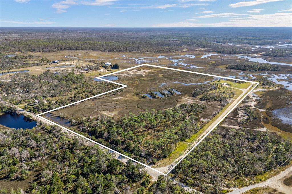 An aerial view shows a large, undeveloped plot of land outlined in white — 125 SW 284, STEINHATCHEE, FL