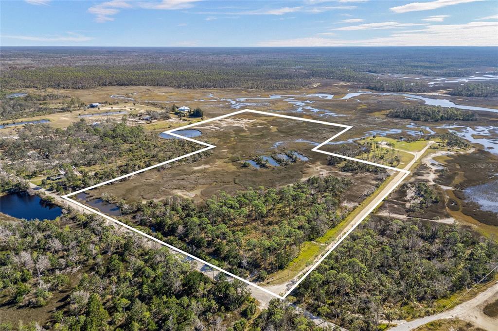 An aerial view shows a large, undeveloped plot of land outlined in white — 125 SW 284, STEINHATCHEE, FL