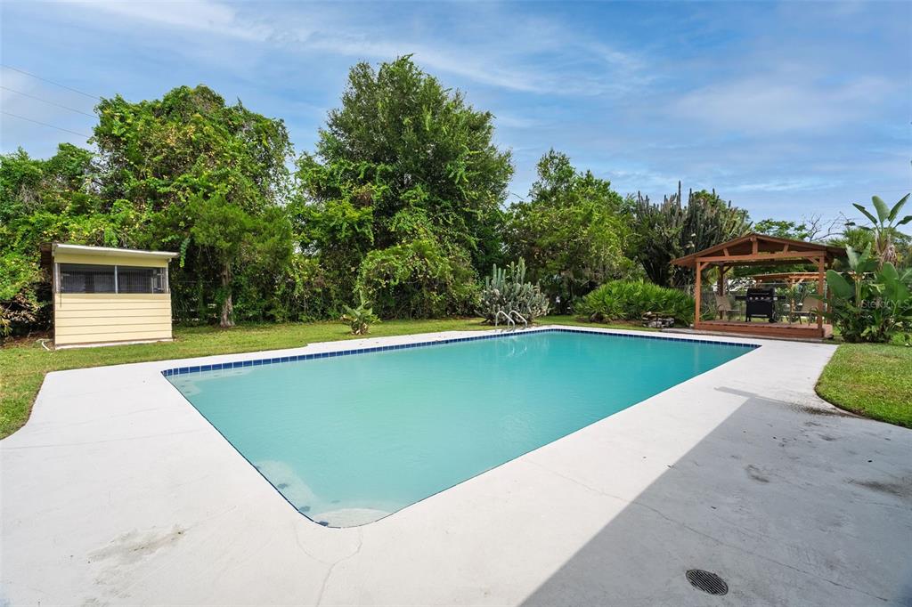 A rectangular swimming pool sits in a backyard with a shed and a wooden gazebo — 7525 LODGE POLE TRAIL, WINTER PARK, FL